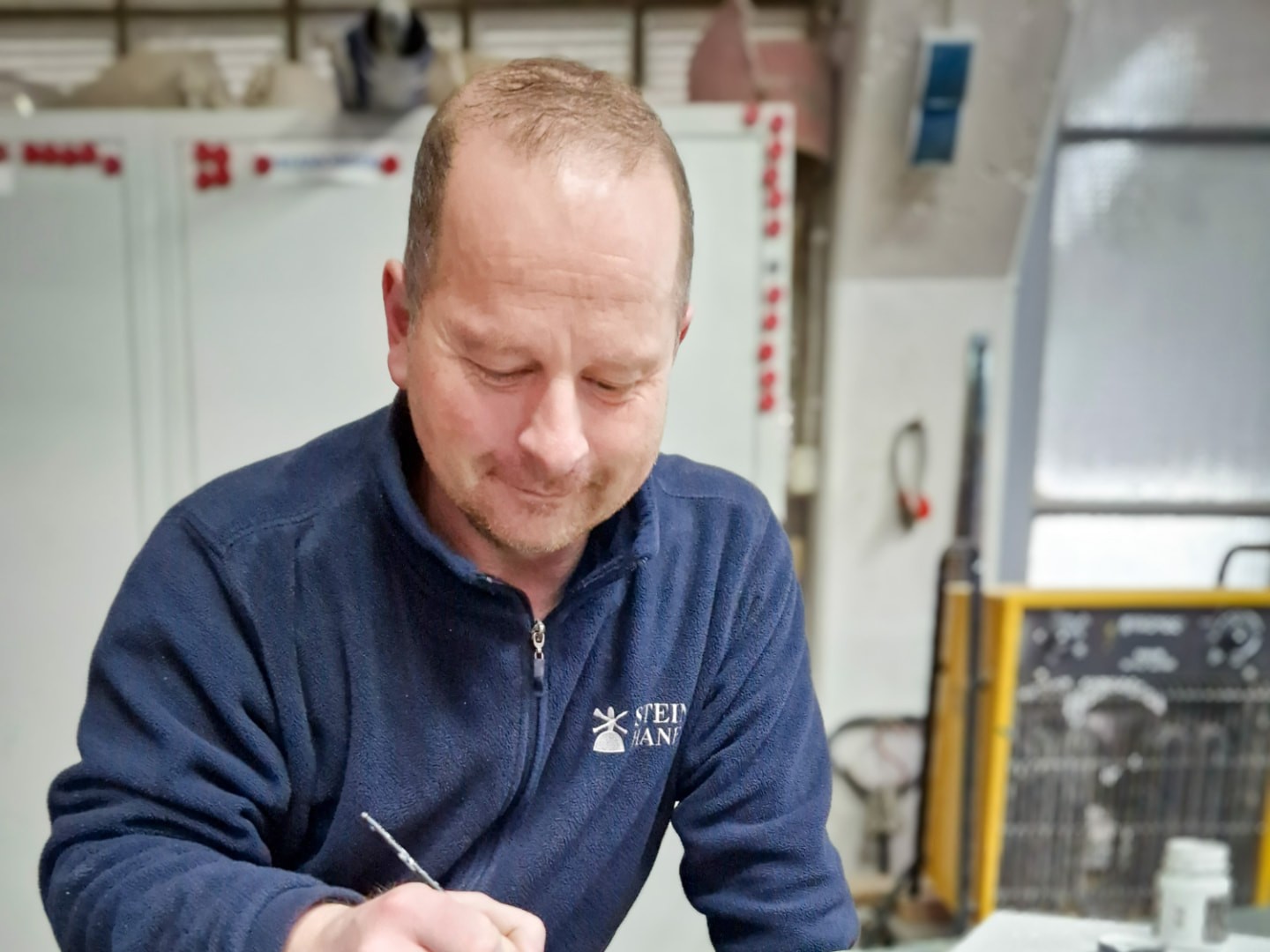 Steinmetz beim Nachziehen der Inschrift eines Grabsteins in der Werkstatt